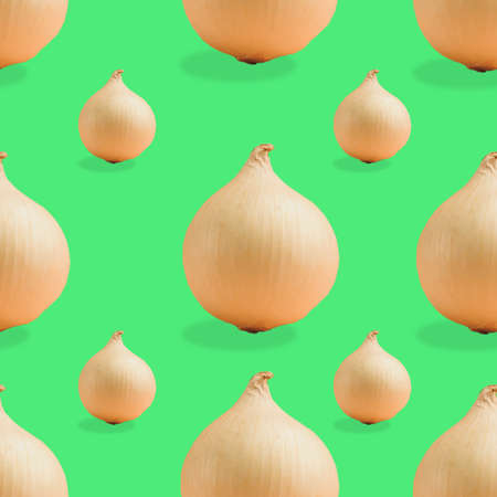 Seamless pattern of white onions of different sizes on a green background. The texture of the food.の写真素材