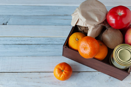 The courier delivered a box of food during the coronavirus pandemic. In the box are fruits,...