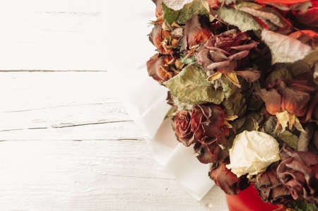 large and beautiful bouquet of dried red and white roses on a white wooden table in the style of Provence. Top view, closeup. Copy space.の写真素材