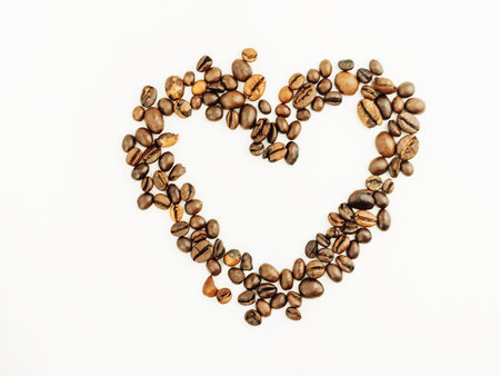 Coffee beans isolated on a white background. Heart made from coffee beans with place for text. Freshly roasted coffee. Love.の写真素材