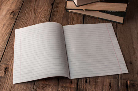Back to school, the concept of raising children. Day of knowledge. Notebook in line on a wooden table with space for text. Save space. Rustic and vintage toning.の写真素材