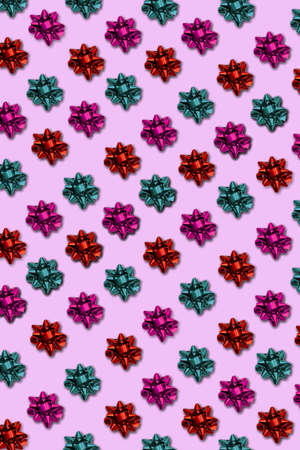 Seamless border stripe of colored packing bows on a pink background. Suitable for holiday wrapping, frames, design cards, greetings, invitations. Christmas gift wrapping.の写真素材