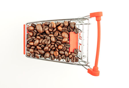 Shopping cart with coffee beans on a white background. Top view, isolate. Concept of the coffee industry.の写真素材