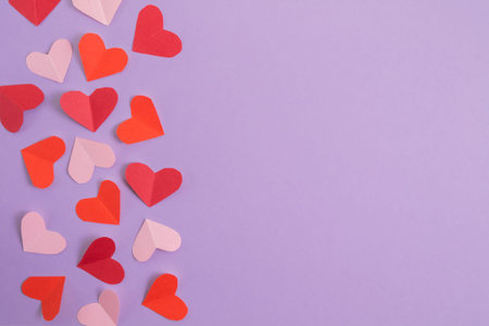 Valentines Day background. Pink and red hearts on a pastel purple background. Valentines Day...