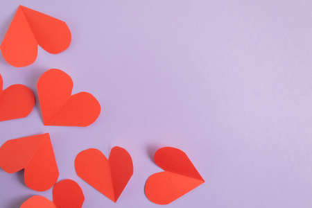 Valentines Day background. Pink and red hearts on a pastel purple background. Valentines Day concept. Layout for postcards and congratulations. Flat lay, top view, copy spaceの写真素材