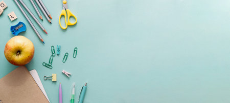 Back to school concept. Wooden colored pencils, blank school notebook, paper clips, apple and other...