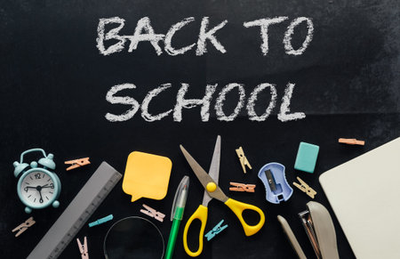 stationery on a shabby graphite table with leftover chalk and back to school inscription. Template...