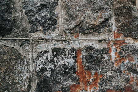 The texture of a stone medieval castle wall with natural defects. Scratches, cracks, crevices, chips, dust, roughness, abrasion. Template for design and background.Copy spaceの写真素材