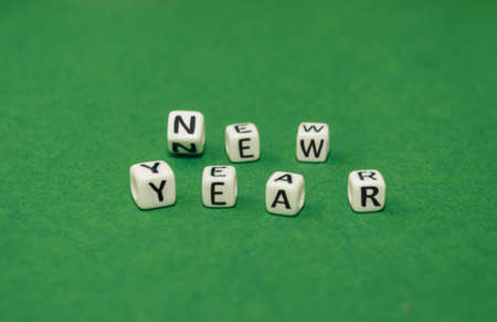New Year concept - inscription New Year on plastic blocks. On a green background. Mockup for a postcard. Template for design. Copy space.の写真素材