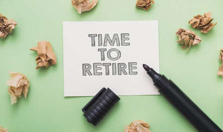 marker write time to retire on a white sticker with crumpled pieces of paper next to it.の写真素材