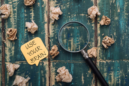 The inscription on the yellow sticker - USE YOUR BRAIN on a green wooden background, a magnifying...