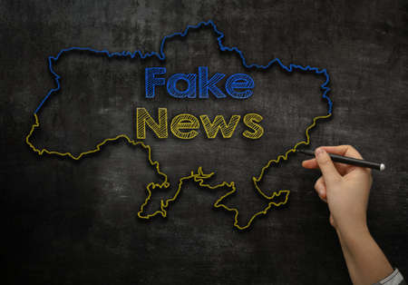 the girl writes on the blackboard the text fake news in the map of Ukraineの写真素材
