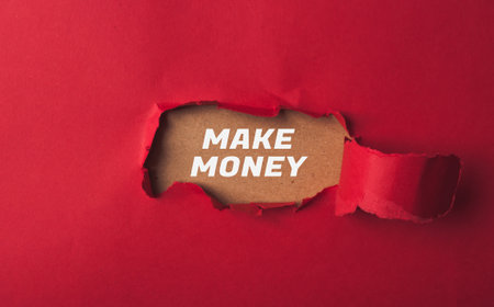 Text on the background of red paper with a hole make money. high quality photoの写真素材