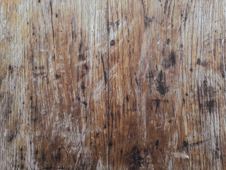 The image is of a wooden surface with a lot of scratches and marks. The surface appears to be old and worn, giving it a sense of history and characterの写真素材