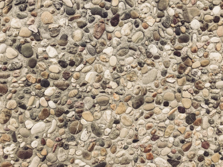 A rocky surface with a variety of sizes and shapes of rocks. The rocks are scattered all over the surface, creating a rough and uneven texture. Concept of ruggedness and natural beautyの写真素材