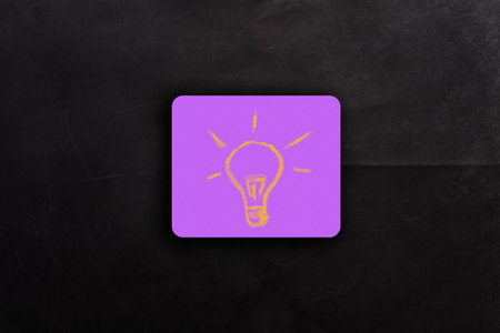 Idea in the form of a light bulb on pink note paper. High quality photoの写真素材