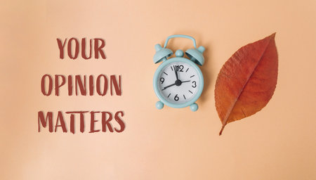A clock with the hands on the numbers 3 and 9. The words Your Opinion Matters are written below the clockの写真素材