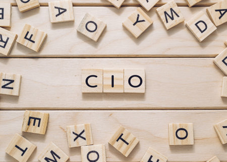 A wooden board with a jumble of letters and numbers scattered across it. The letters and numbers are arranged in a way that spells out the word CIO in the center of the boardの写真素材