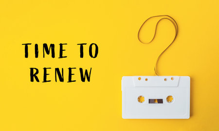 A white cassette tape is hanging from a string with the words Time to Renew written below it