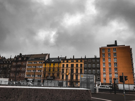 A city skyline with a cloudy sky and a few buildings. The buildings are of different heights and...