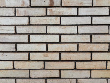 A brick wall with a white brick pattern. The wall is made of white bricks and has a rough textureの写真素材