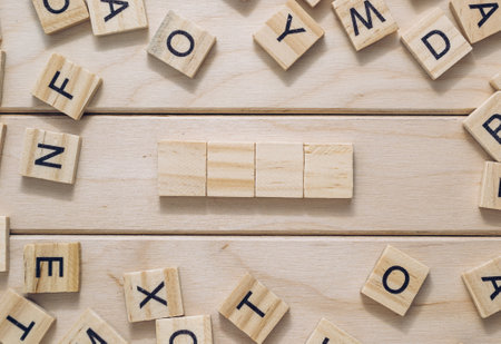 A wooden board with a crossword puzzle on it. The puzzle is made up of wooden blocks and lettersの写真素材