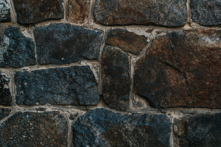 A wall made of stone with a blue and gray color. The wall is very rough and has a lot of texture
