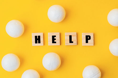 A yellow background with a large group of white balls scattered around it. The word help is written...