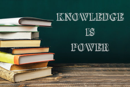 A stack of books with the words knowledge is power written on top. The image conveys the idea that knowledge is a powerful tool that can help people achieve their goalsの写真素材