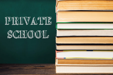 A stack of books with the word Private School written on a chalkboard behind them. The books are...
