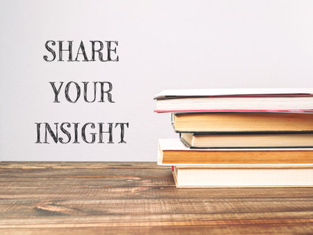 A stack of books with the words share your insight written on top. The books are piled on a wooden table, creating a sense of depth and importance. Concept of sharing knowledge and wisdomの写真素材