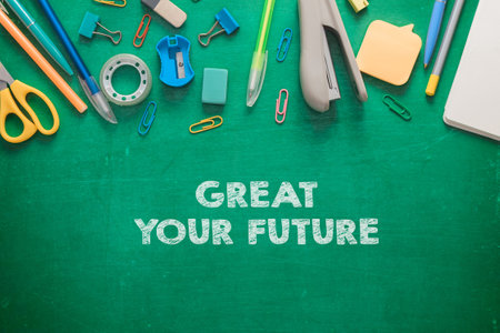 A green chalkboard with a bunch of office supplies and the words Great Your Future written on itの写真素材