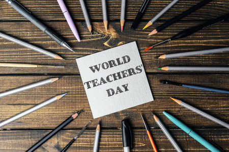 A collection of pencils and pens are arranged in a circle with the words World Teachers Day written in the centerの写真素材