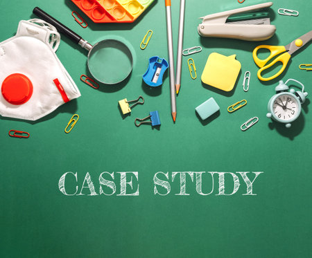 A green background with a case study written on it. The case study is a collection of office supplies such as scissors, a stapler, a pen, and a rulerの写真素材