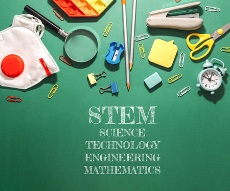 A green background with a bunch of school supplies and the words STEM, Science, Technology, Engineering, and Mathematicsの写真素材
