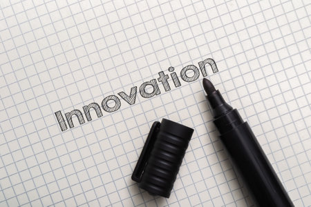 Marker is on a piece of paper with the word innovation written in black marker. Concept of creativity and progressの写真素材