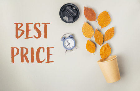 Clock and a cup of leaves are on a table with the words Best Price written below themの写真素材