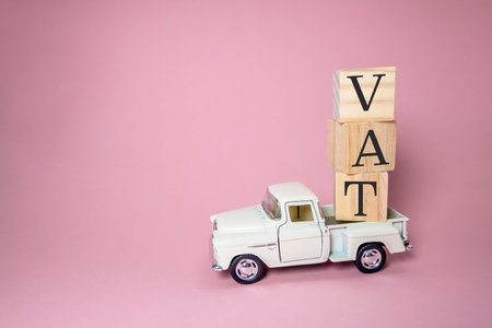 White truck is carrying a stack of wooden blocks with the word VAT on top. Concept of work and productivity, as the truck is being used to transport materialsの写真素材