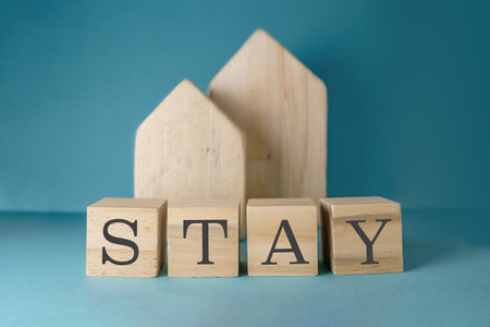 A wooden block with the word stay written on it. There are also two other wooden blocks in the background, which could be part of a larger structure or decorationの写真素材
