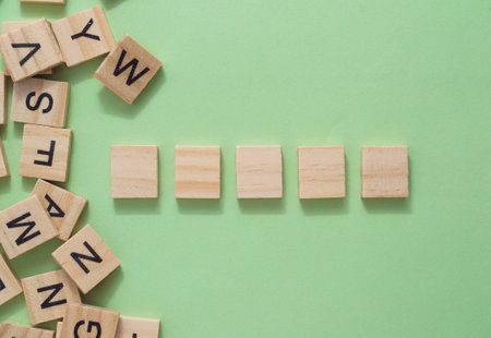 A row of wooden blocks with letters on them, neatly aligned, providing ample space for text or design elements, perfect for copy space or mockup usage.の写真素材