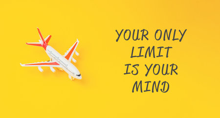 Small airplane is on a yellow background with the words Your only limit is your mind written below itの写真素材
