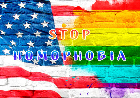 Rainbow flag with the words Stop Homophobia written on it. The flag is on a brick wallの写真素材