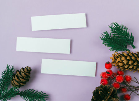 Three white cards are on a purple background with red berries. The cards are blank, suggesting that they are meant to be filled with information or ideas. The red berries add a pop of colorの写真素材