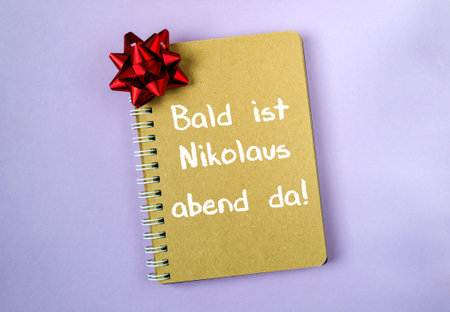 Notebook with a red bow on it and the words Bald ist Nikolas abend da! written on it