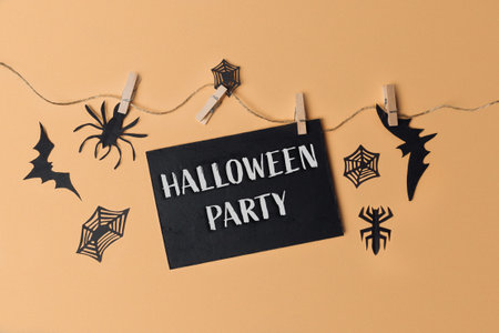 Halloween party sign hanging from a string. The sign is black and white and has a spider web designの写真素材