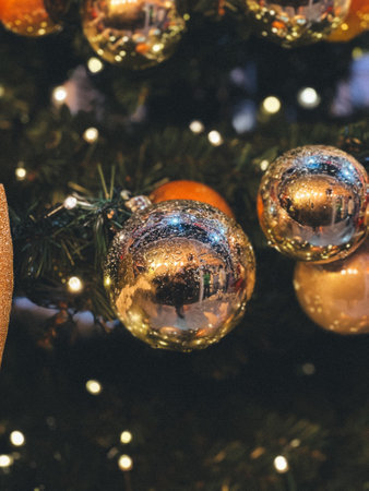 A tree with many shiny gold and silver ornaments on it. The tree is lit up with lightsの写真素材
