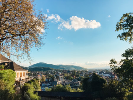 A city view with a cloudy sky and a house in the background. The sky is blue and the clouds are whiteの写真素材