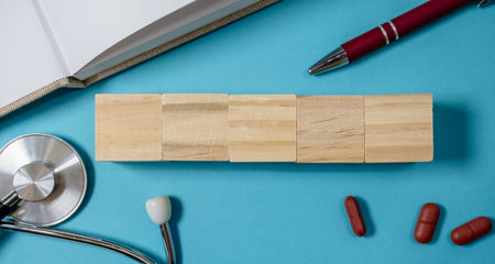 Stack of wooden blocks sits on a blue surface next to a pen and a stethoscope. Concept of creativity...