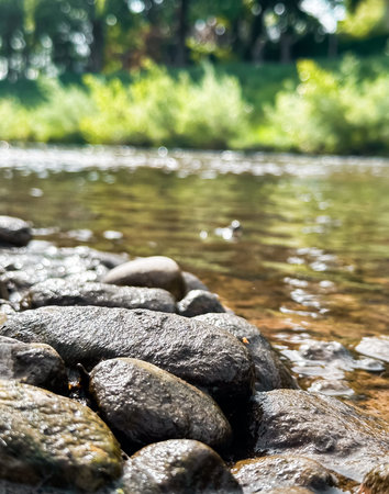 Rocky shoreline with a body of water in the background. The water is calm and the rocks are...