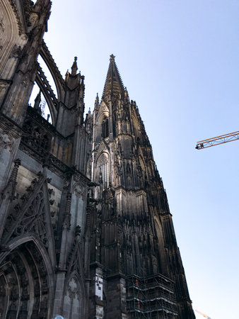 Tall building with a pointed roof and a blue sky in the background. The building is old and has a Gothic styleの写真素材